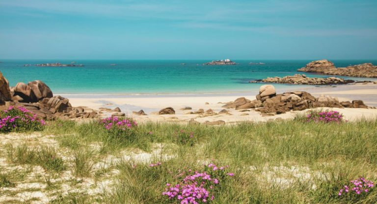 Plage sauvage de Bretagne avec rochers de granite rose et mer turquoise sous ciel bleu