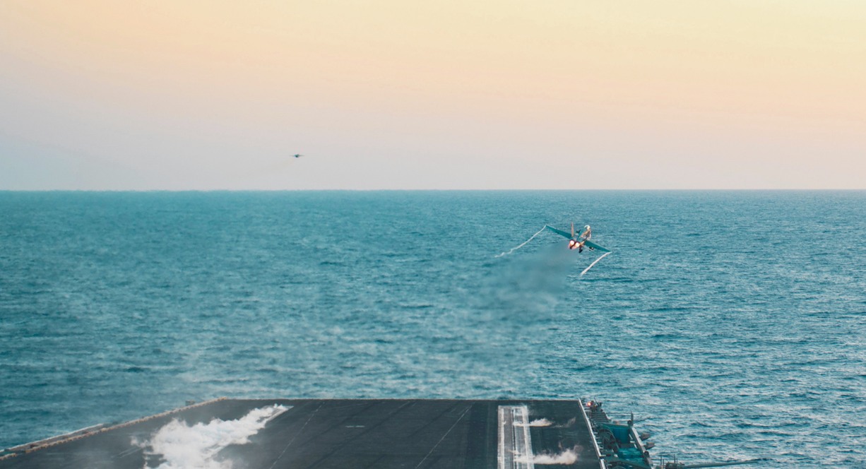Avion militaire catapulté depuis le pont d'un porte-avions en mer, symbole du coût colossal d'un tel bâtiment de guerre