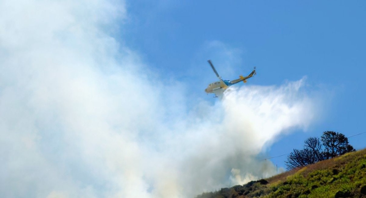 Aeronef de lutte contre les incendies larguant de l'eau au-dessus d'un feu de vegetation