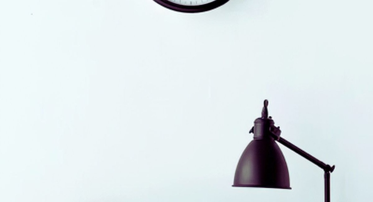 Horloge murale et lampe de bureau dans un espace de travail epure