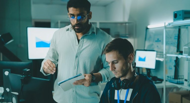 Deux informaticiens analysent des données sur une tablette dans une salle technique
