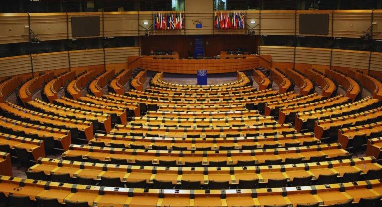 Hemicycle du Parlement europeen avec rangees de sieges et drapeaux des Etats membres