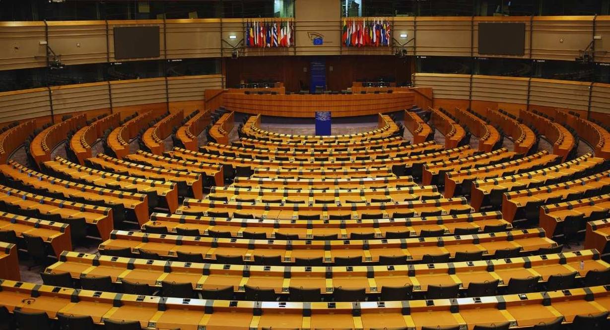 Hemicycle du Parlement europeen avec rangees de sieges et drapeaux des Etats membres