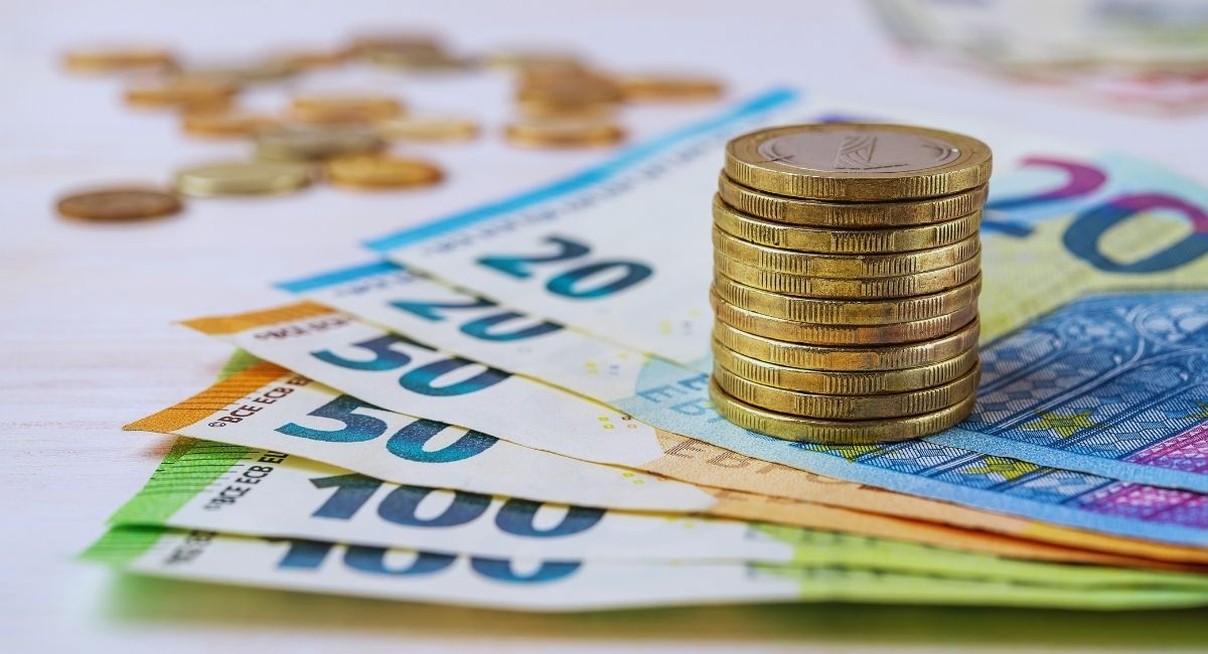 Billets en euros de differentes valeurs et pile de pieces en euros