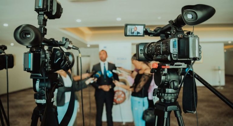 Homme interviewe devant des cameras de television lors d'une conference de presse