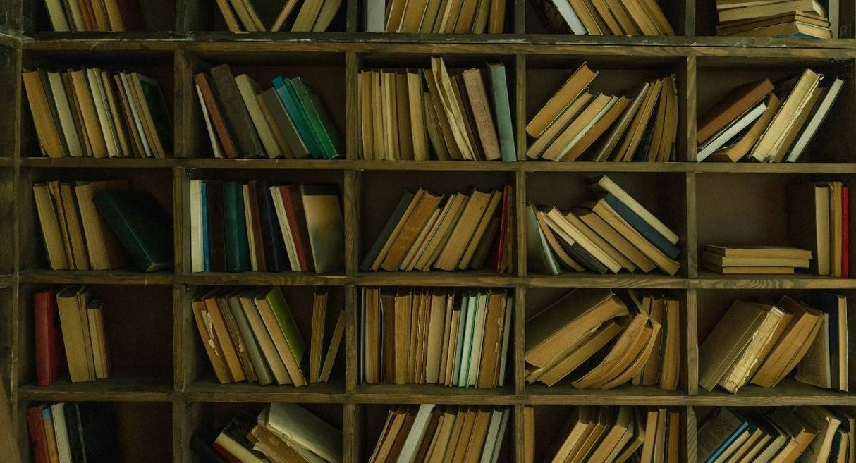 Etagere en bois remplie de vieux livres empiles